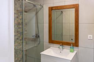 a bathroom with a sink and a shower with a mirror at Beach & Sea Guesthouse in Espinho +49 photos
