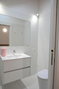 Baño blanco con lavabo y aseo en Casa do Pó, Alojamento Local en Lamego