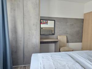 a bedroom with a bed and a desk and a mirror at Premium Apartments Tade Funtana in Funtana