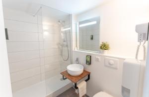 une salle de bain blanche avec un lavabo et une douche dans l'établissement Hotel Inn Design La Rochelle, à La Rochelle 53 autres photos