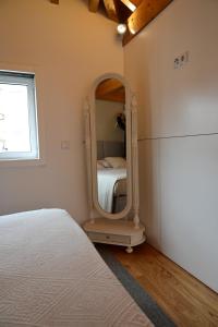 um quarto com um espelho e uma cama em Casa do Pó, Alojamento Local em Lamego
