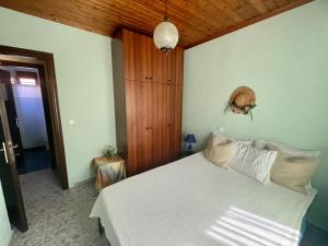 a bedroom with a white bed and a wooden ceiling at Miro & Lana vacation home in Kinira