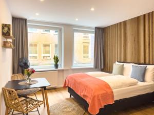 Schlafzimmer mit einem Bett, einem Tisch und einem Fenster in der Unterkunft Lorenz Apartments in Nürnberg