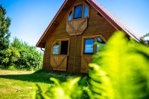a small wooden house with windows and a porch at Villa Zastań in Międzywodzie