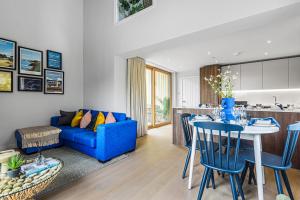 uma sala de estar com um sofá azul e uma mesa em Chi An Treth em Hayle