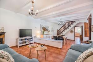 ein Wohnzimmer mit einem Sofa und einem TV in der Unterkunft Can De L'ausina in Pollença