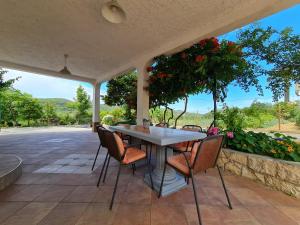 einen Tisch und Stühle auf einer Terrasse mit Blumen in der Unterkunft Apartment Gulić in Rab