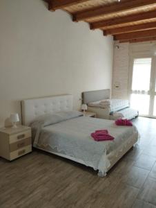 a bedroom with a bed and a dresser and a window at Angelo's Country House in Bernalda