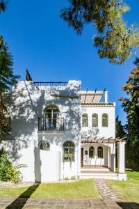 a white house with a balcony on top of it at Tropical Getaway Townhouse in Nueva Andalucia close to Los Naranjos Golf in Marbella
