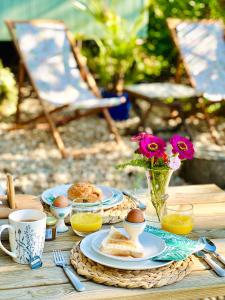 a wooden table with breakfast foods and drinks on it at The Green Hut in Battle