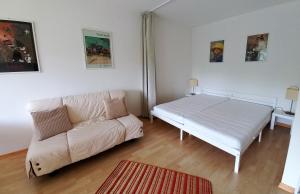 a living room with a white bed and a couch at CHRISTOPH Haus KMB Seeappartement am Ossiacher See mit direktem Seezugang und Hallenbad in Tschöran
