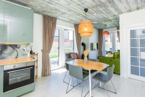 a kitchen and dining room with a table and chairs at Žalia Kopa apartamentai in Palanga