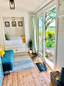 a bedroom with a bed and a sliding glass door at The Green Hut in Battle