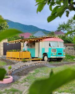 an old truck parked in front of a house at Pavlove Tiny Bus House in Qabala in Gabala