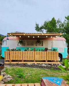 a caravan with awning and a fence in front of it at Pavlove Tiny Bus House in Qabala in Gabala