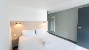 a bedroom with a large white bed with a window at Hotel Inn Design La Rochelle in La Rochelle