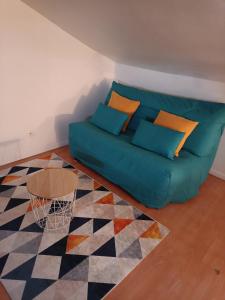 uma sala de estar com um sofá e uma mesa em Le Richelieu 3 chez Adrien em Saint-Quentin