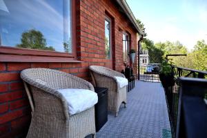 a patio with wicker chairs and a brick wall at Villa with mountain view in the Swedish High Coast in Docksta