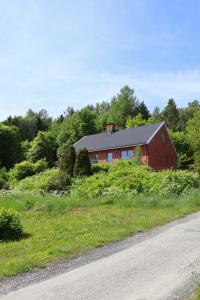 a red house on the side of a road at Villa with mountain view in the Swedish High Coast in Docksta