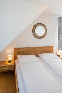 a bedroom with two beds and a mirror on the wall at mivida - Apartment Geierkogel in Hohentauern