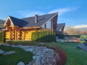 a log cabin with a creek in front of it at Alpina Luxury Chalets in Banya