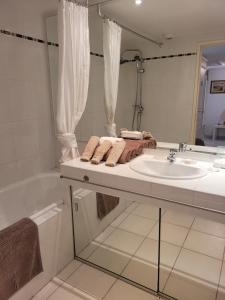y baño blanco con lavabo y bañera. en VILLENEUVE LOUBET PLAGE- Entre NICE et CANNES, en Villeneuve-Loubet