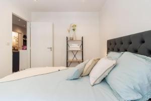 a bedroom with a large white bed with pillows at "Le petit bonlieu" au centre ville et à 500m du lac in Annecy