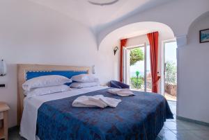 a bedroom with a bed with a blue comforter at Don Felipe Boutique Hotel in Ischia