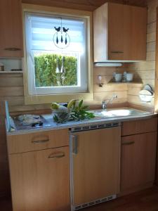 eine Küche mit einem Waschbecken und einem Fenster in der Unterkunft Bungalow "Heimliche Liebe" in Bansin