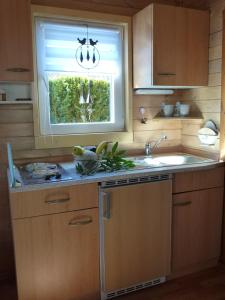 una cocina con fregadero y ventana en Bungalow "Heimliche Liebe", en Bansin