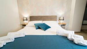 uma grande cama branca com almofadas azuis em Sensoria Naxos Suites em Giardini Naxos