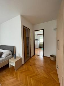 sypialnia z łóżkiem i drewnianą podłogą w obiekcie Homestay J&M w Bledzie