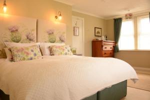 um quarto com uma grande cama branca com flores em Scourie Hotel em Scourie