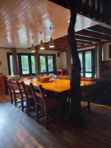 una mesa de madera con sillas y un árbol en una habitación en Riverfront View - House on Blyde, en Kampersrus AH