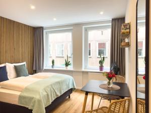 sypialnia z łóżkiem, stołem i oknami w obiekcie Lorenz Apartments w Norymberdze