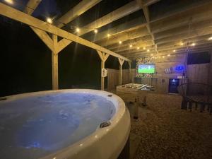 a large bath tub in a room with a tv at Cariad in Tenby