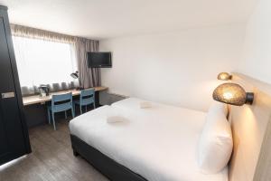 a hotel room with a bed and a desk at Hôtel Inn Design La Rochelle in La Rochelle