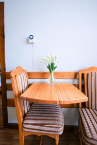 a wooden table and chairs with a vase of flowers at Tisa Hotel in Kyiv