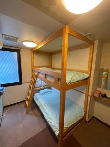 two bunk beds in a room with a window at 遊悠館 in Tokyo