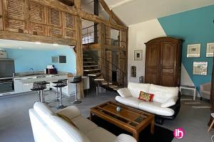 Una sala de estar con dos sofás blancos y una mesa. en Oestuaire, en Gauriac