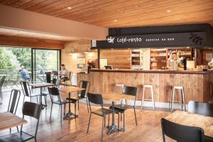 a restaurant with wooden walls and tables and chairs at CityKamp Colmar in Horbourg