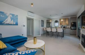a living room with a blue couch and a kitchen at Tea Deluxe Apartment with private Pool in Malinska