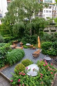 un jardín con sillas, mesas y flores en Adveniat Paris, en París