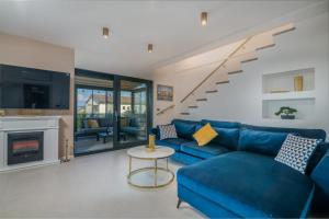 a living room with a blue couch and a fireplace at Tea Deluxe Apartment with private Pool in Malinska