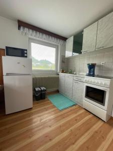 Il comprend une cuisine équipée d'appareils électroménagers blancs et d'un réfrigérateur blanc. dans l'établissement Homestay J&M, à Bled