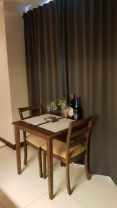 a wooden table with two chairs and wine glasses at 101 Newport blvd C2 4F by Rechelle Nunag in Manila