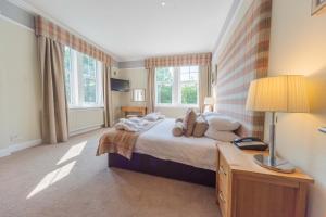 a bedroom with a bed and a lamp and windows at Tinto Hotel in Symington