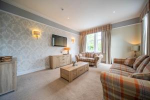 a living room with two couches and a tv at Tinto Hotel in Symington