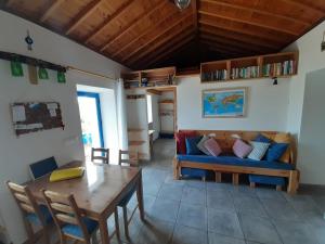 Cosy Private Cottage w/sea views & wifi في فيلا دو بورتو: غرفة معيشة مع أريكة وطاولة