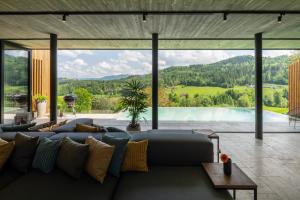 un soggiorno con divano e una grande finestra di steiRerBLiCke - Weingartenresidenz Guntschenberg 